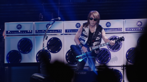 Tak performing with his latest signature instrument styled after the Gibson Firebird.